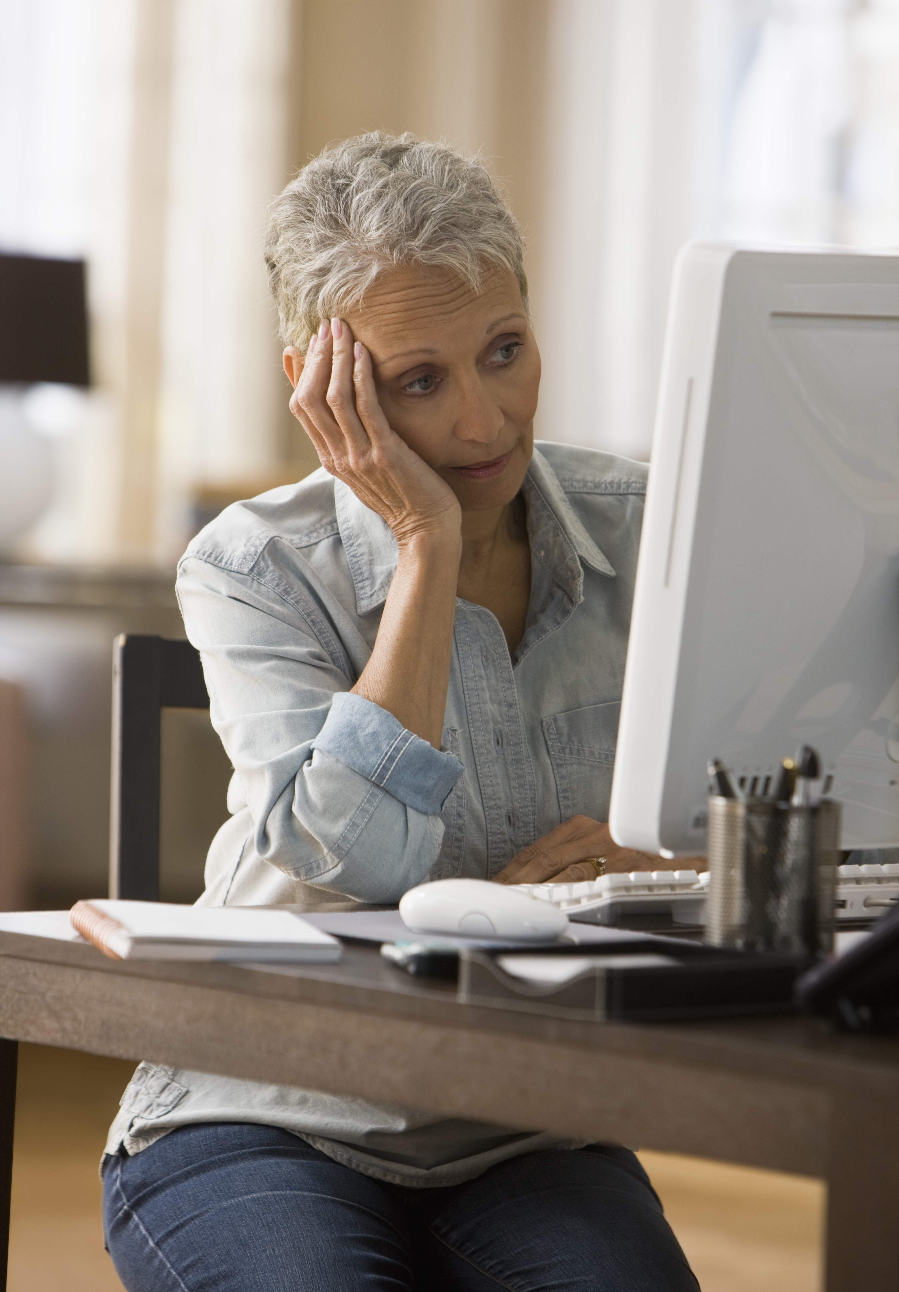A woman looking bored in front of her computer