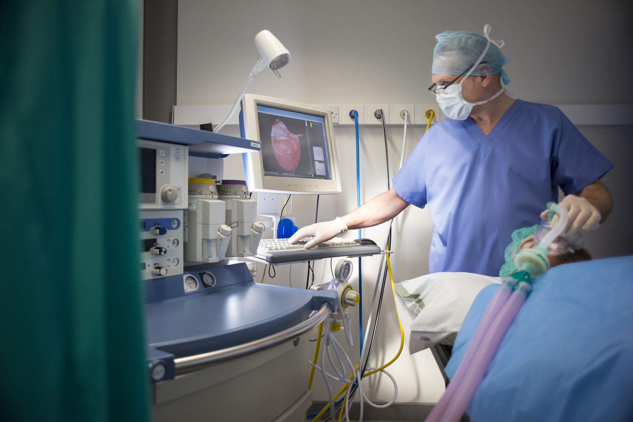 A doctor holding a gas mask over a patient&#x27;s face