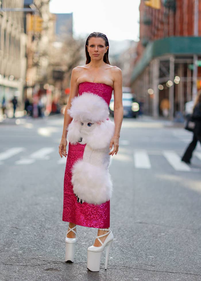 Julia Fox on the street wearing a strapless column dress with a 3D poodle on the front and extreme platform high heels