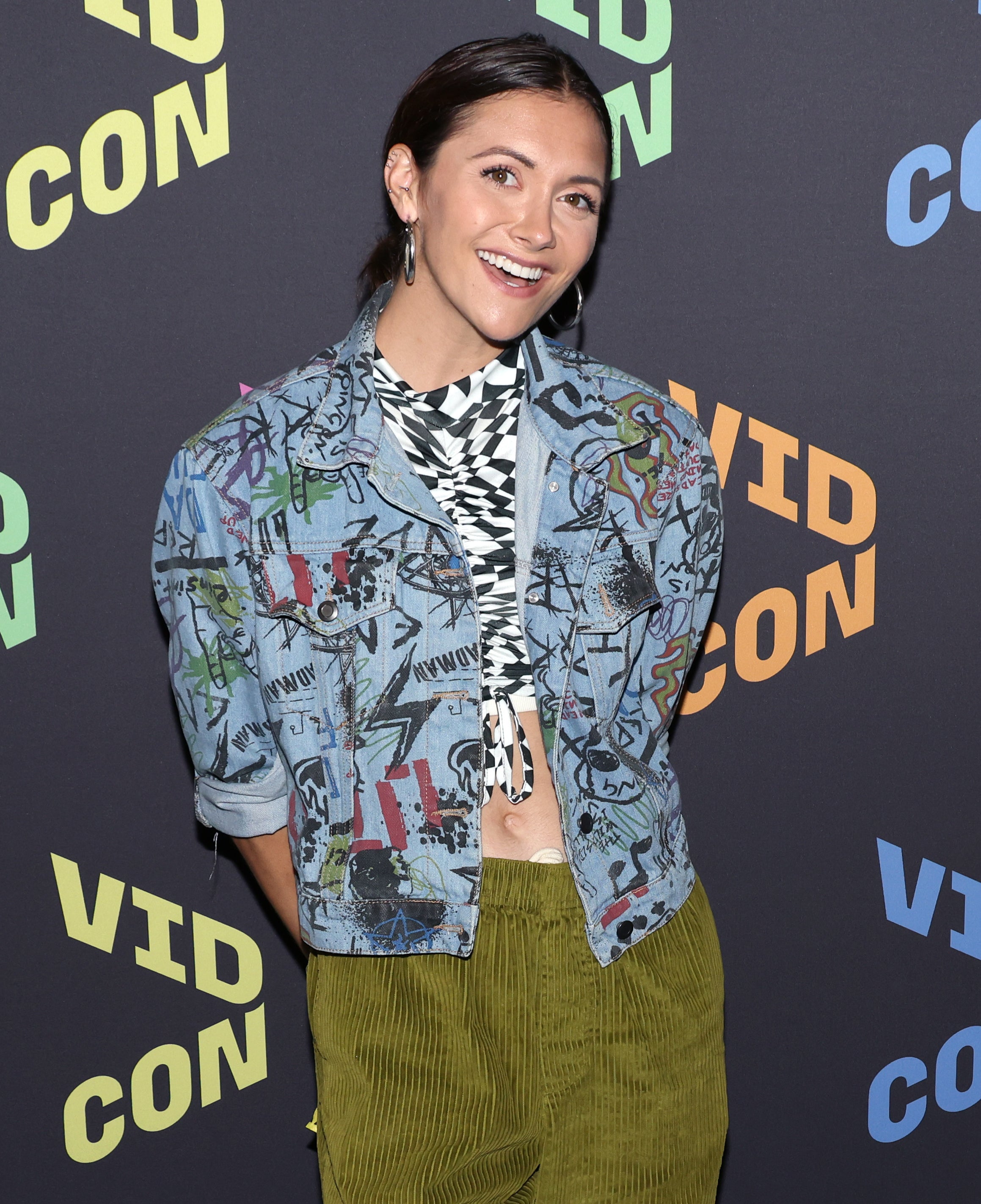 Smiling Alyson wearing a graffiti jacket and pants