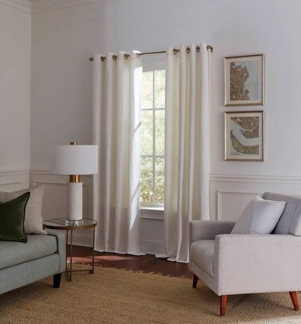 A white curtain hanging in a living room.