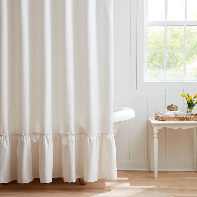 A shower curtain hanging over a clawfoot tub.