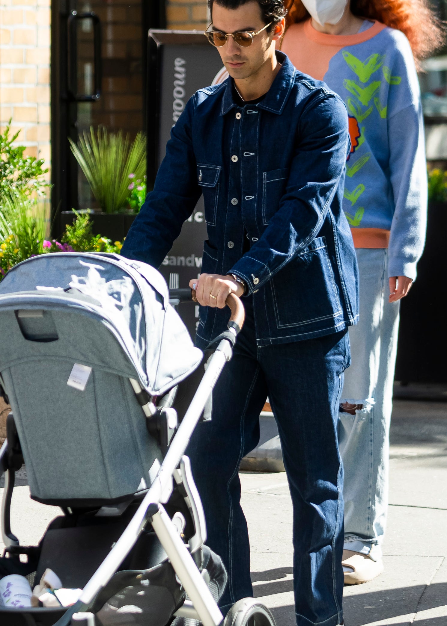 Close-up of Joe pushing a baby carriage with Sophie