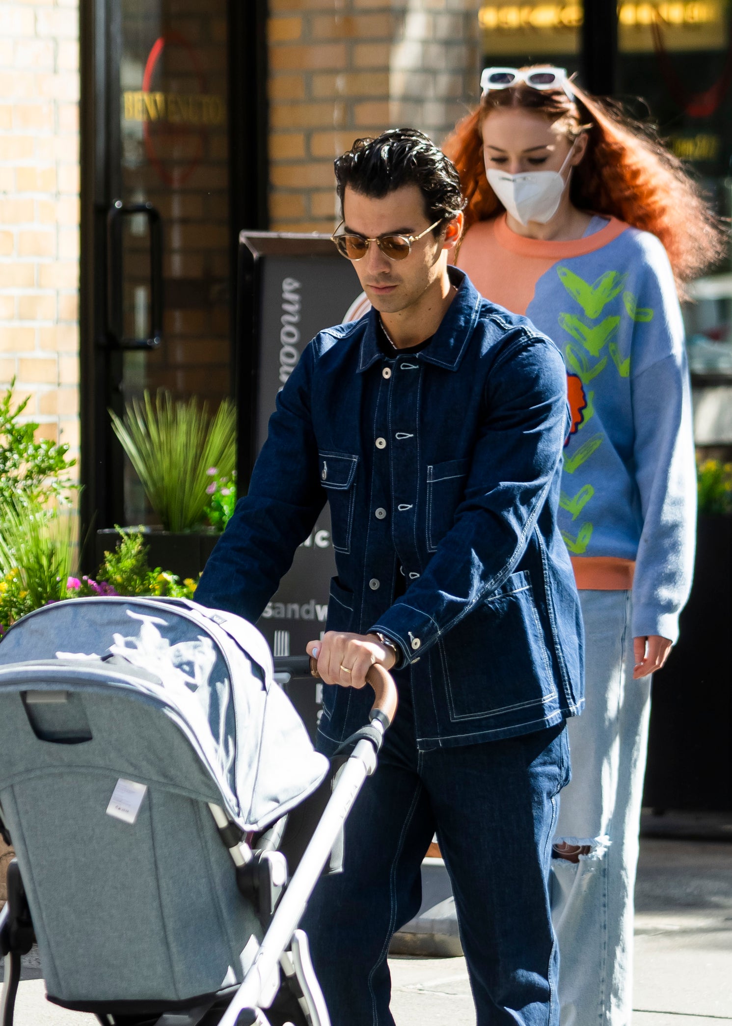 Close-up of Joe pushing a baby carriage with Sophie