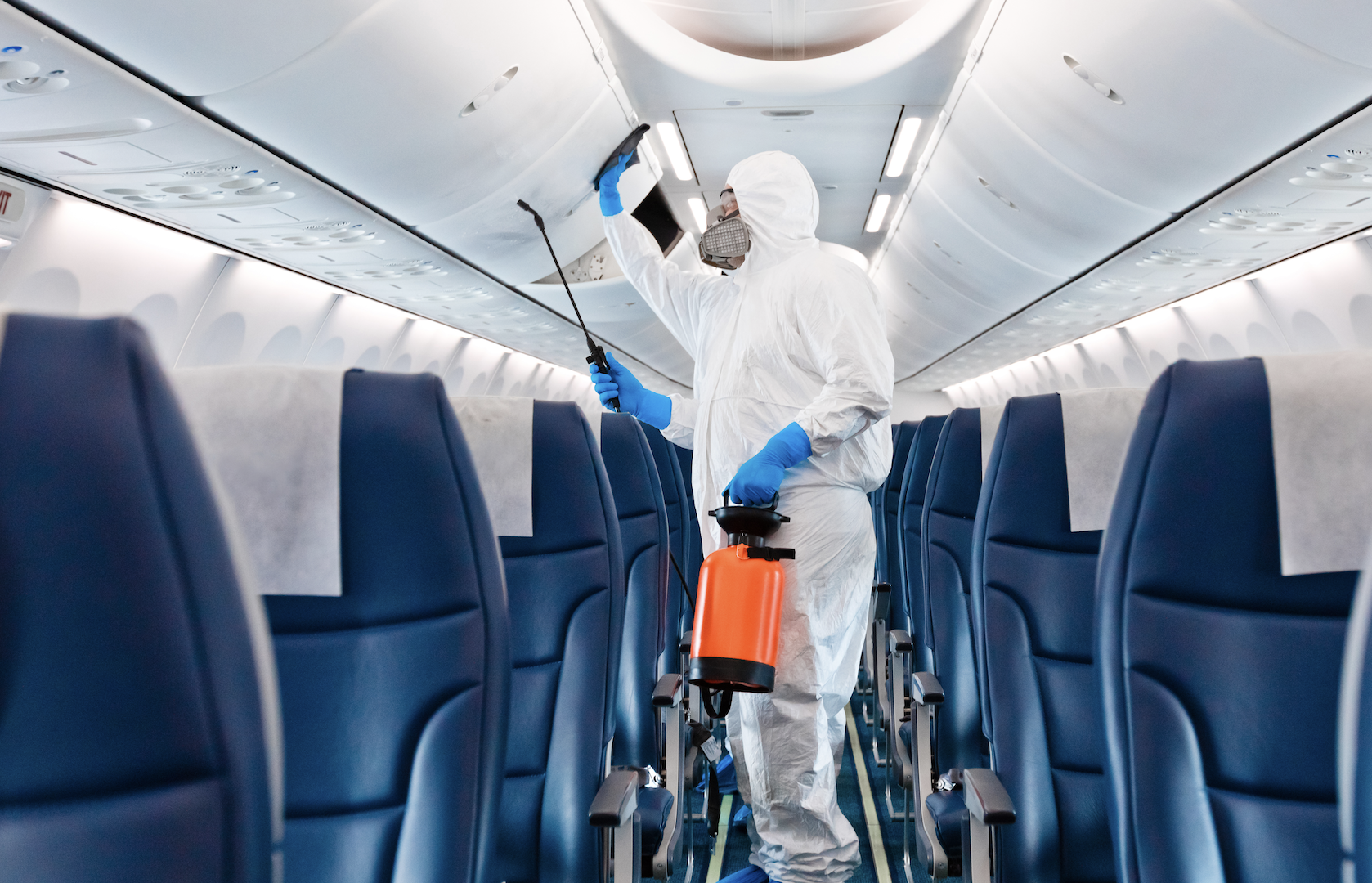 Person disinfecting an airplane in a hazmat suit