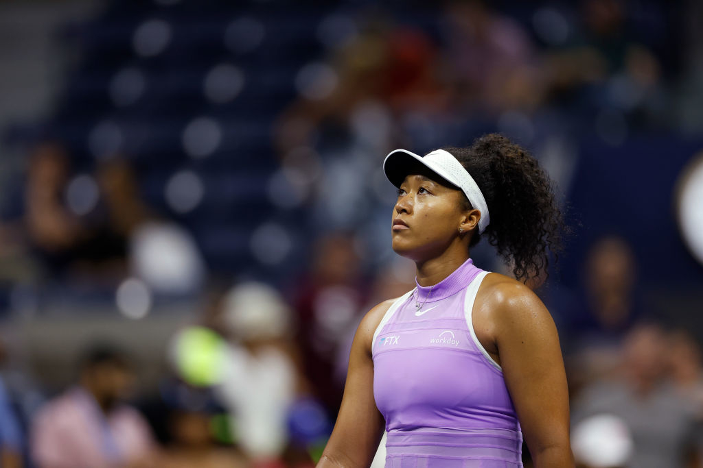 Naomi Osaka looks up as she walks on a tennis court