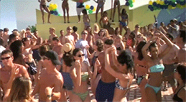 a bunch of people dancing on the beach at a party
