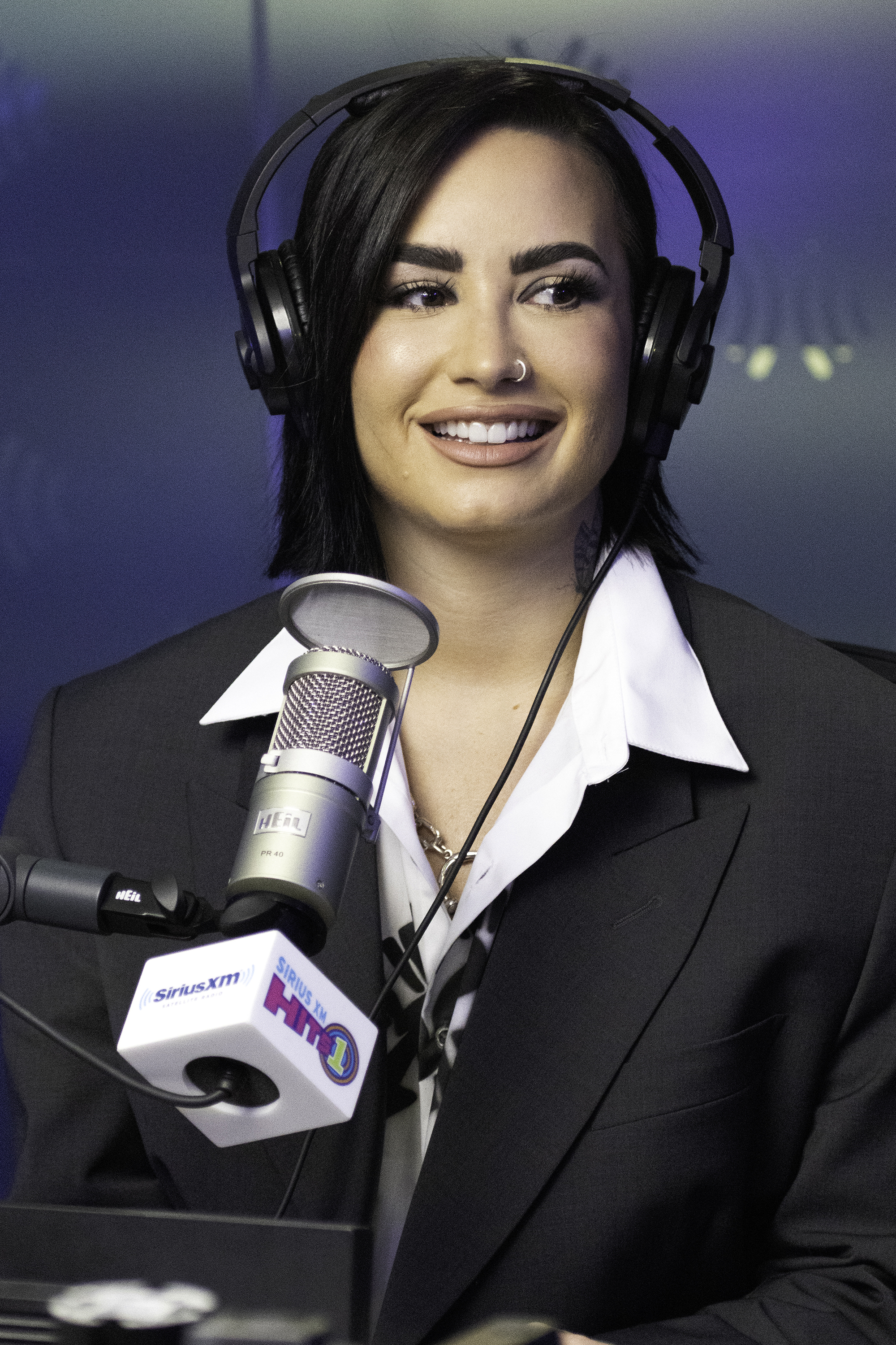 A closeup of Demi Lovato sitting in front of a microphone during an interview