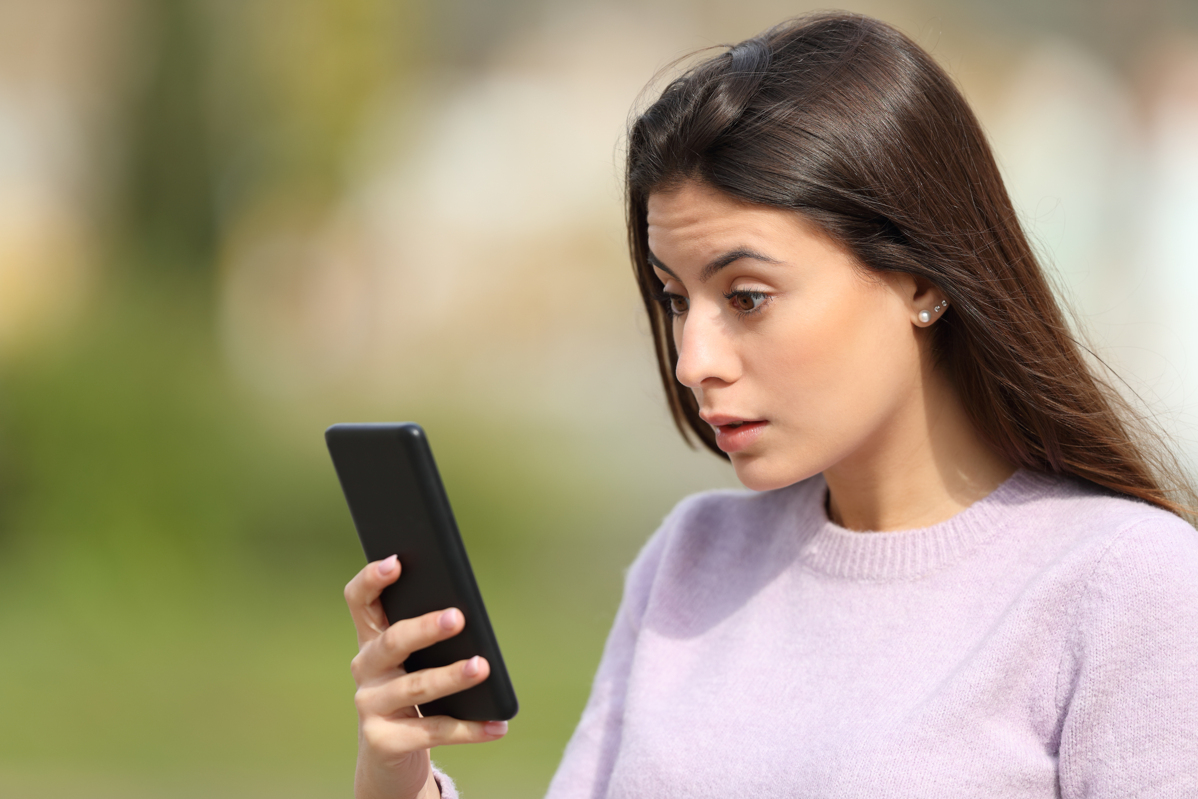 person looking at their phone in shock