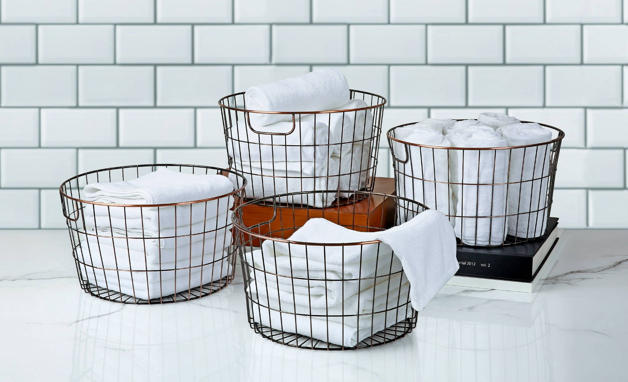 the four wire baskets with linens in them