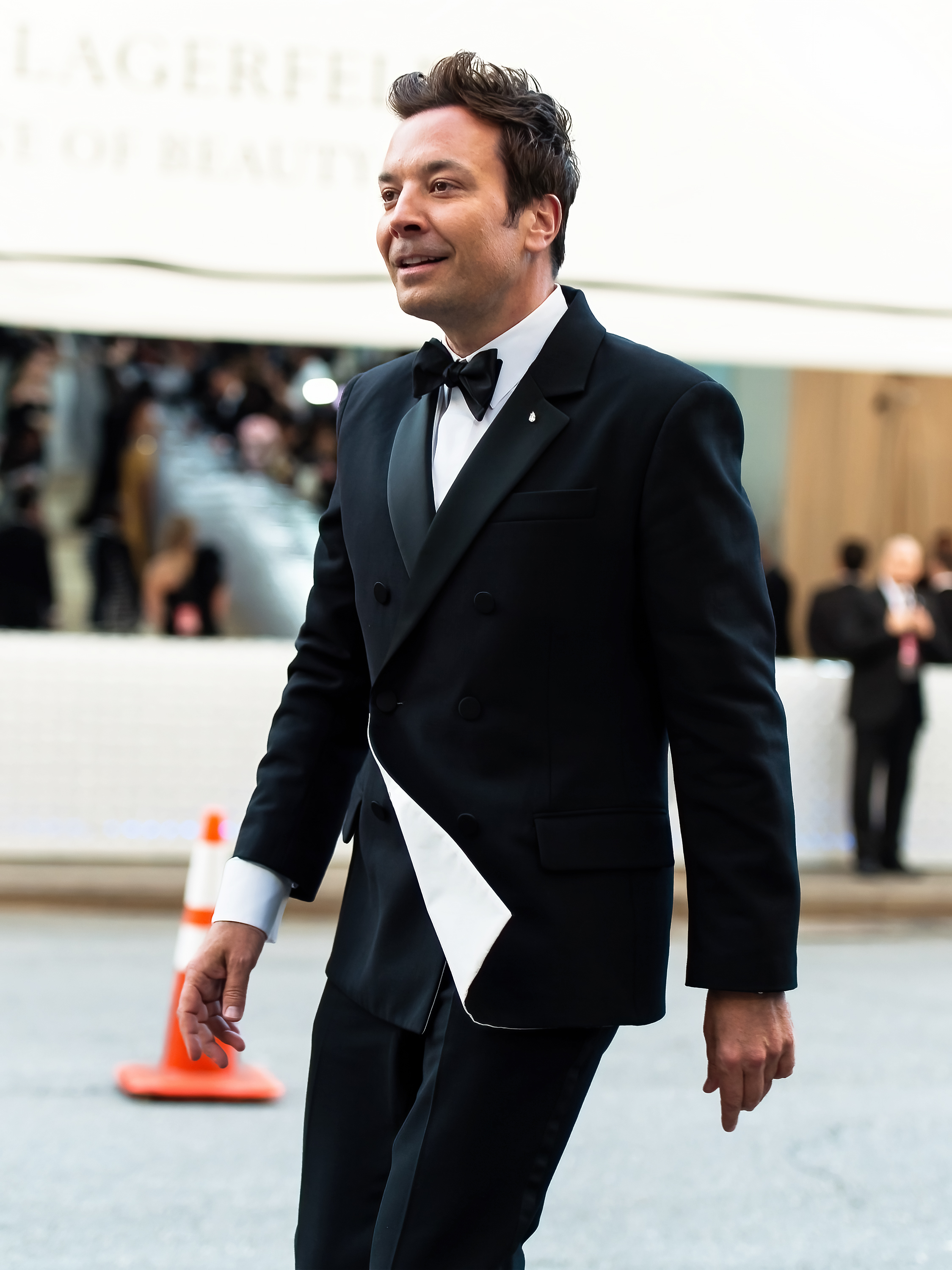 Jimmy Fallon wearing a tuxedo as he walks outside at an event