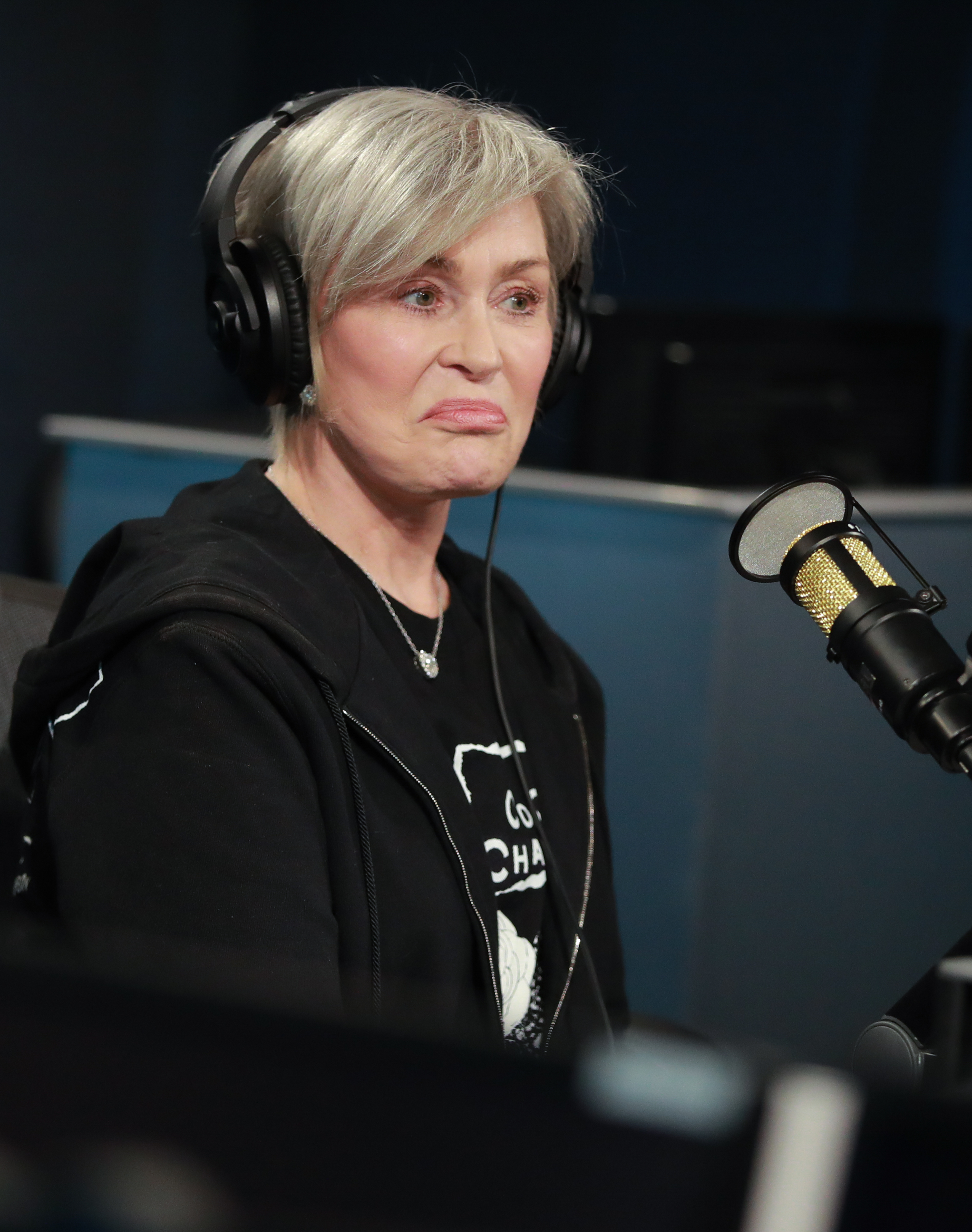 Close-up of Sharon seated in front of a microphone and wearing headphones
