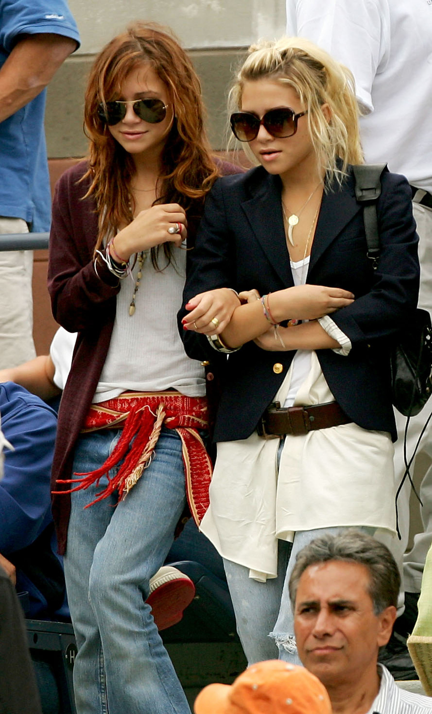 Mary-Kate and Ashley Olsen walking down the steps to their seats; both are wearing sunglasses and jeans