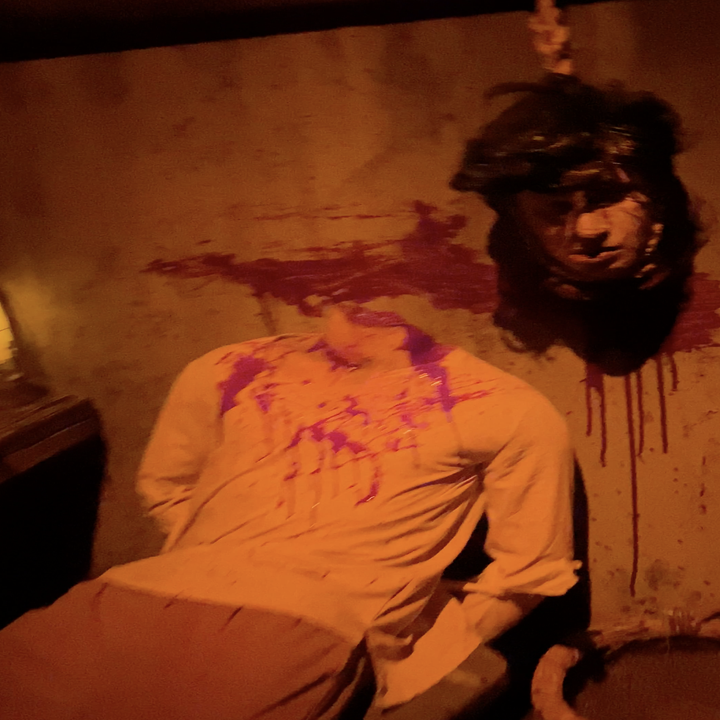 headless body next to a hanging head