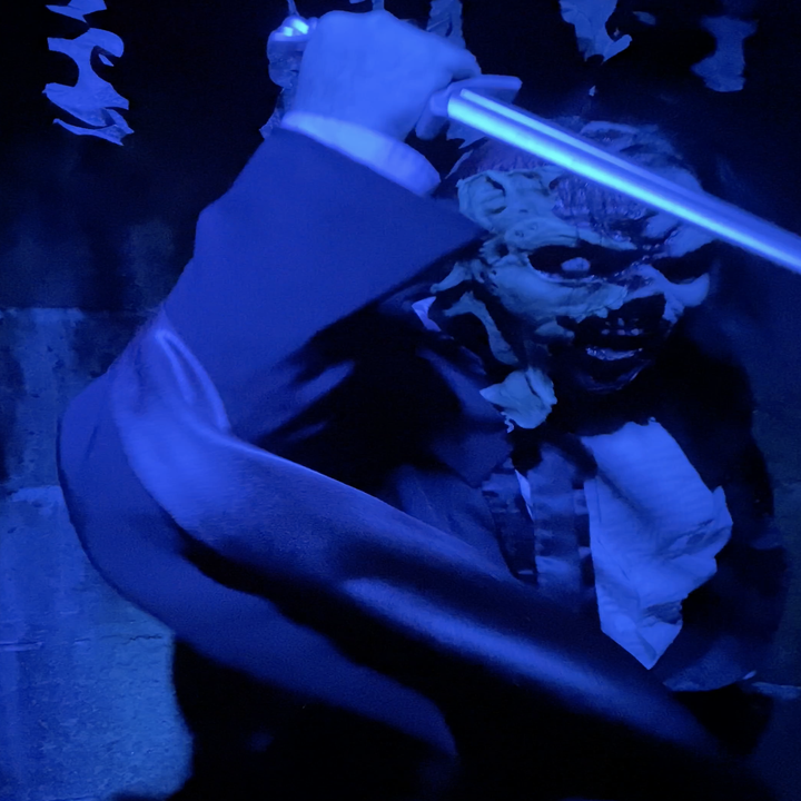 person in a scary mask holding a sword