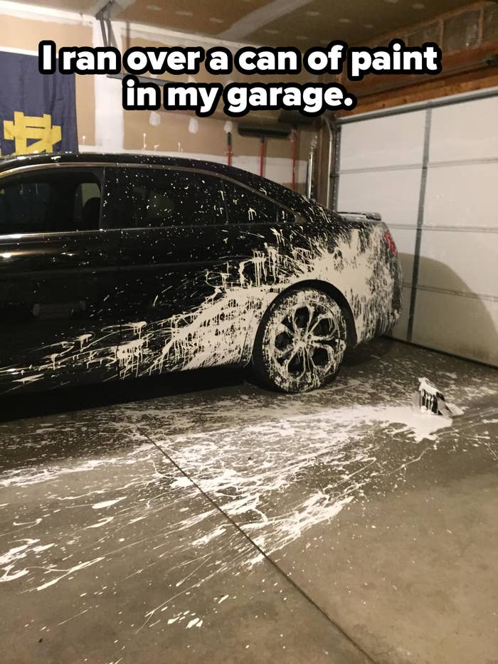 A car with white paint all over it and on the garage floor, with caption "I ran over a can of paint in my garage"