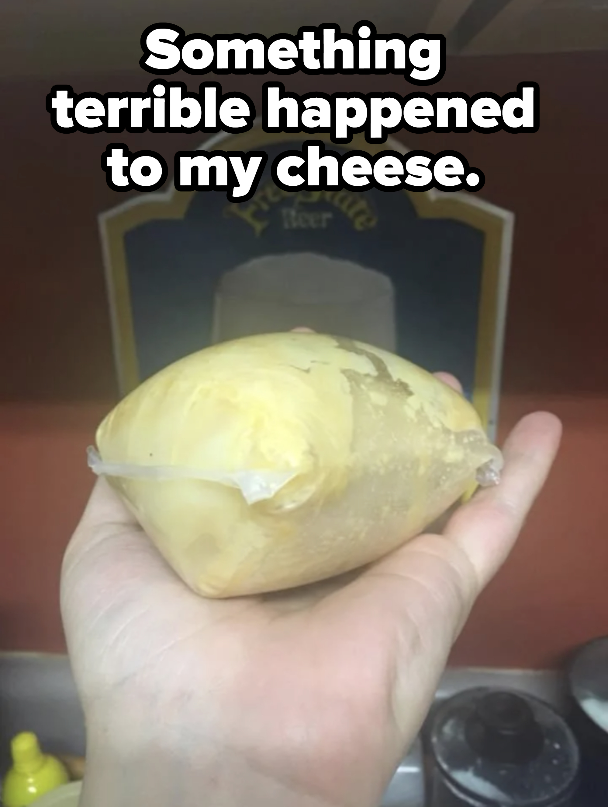 A hand holding a bloated package of cheese with caption &quot;Something terrible happened to my cheese&quot;