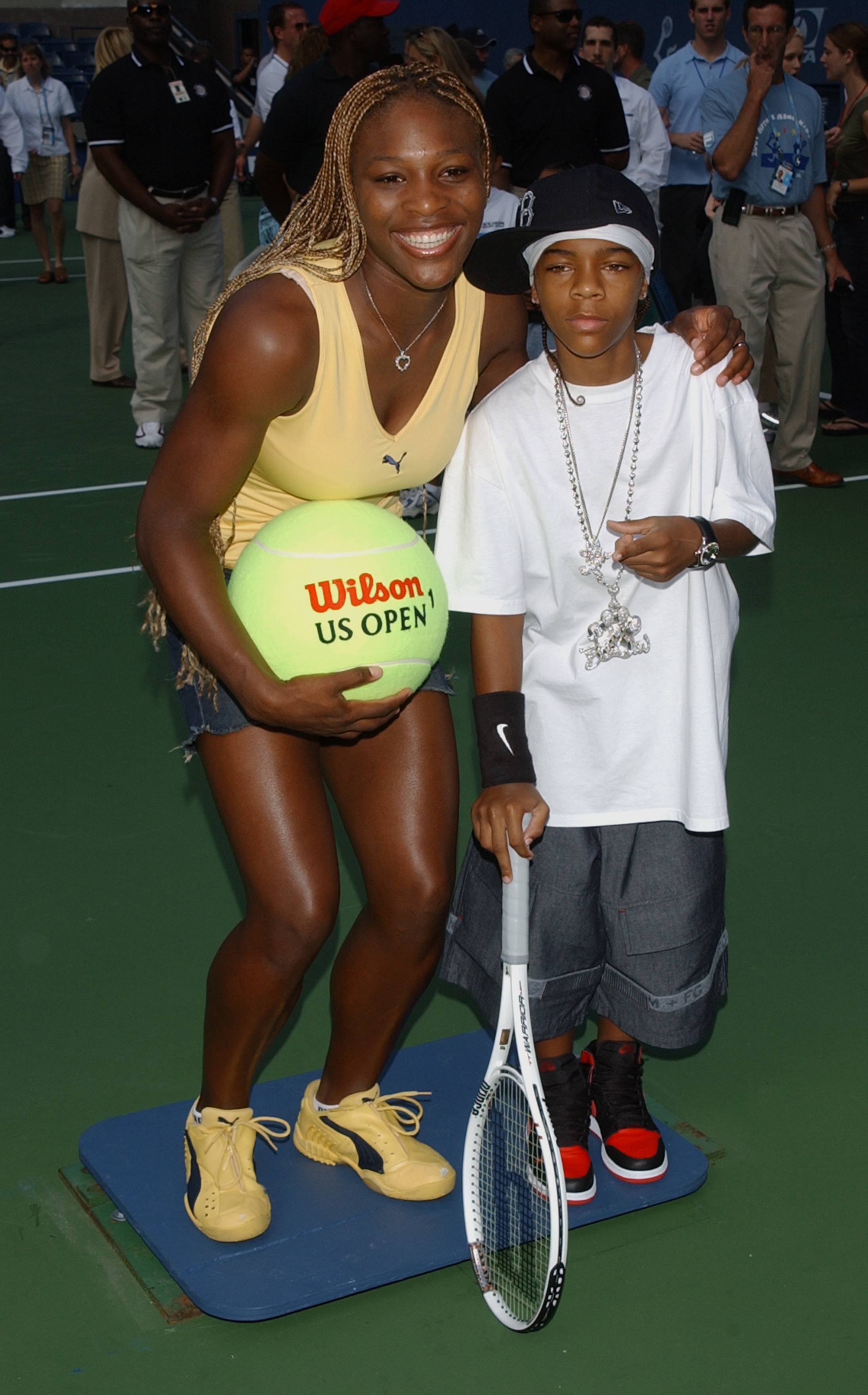 Serena, holding a Wilson US Open ball, smiles as she bends down to take a picture with Lil&#x27; Bow Wow, who&#x27;s holding a tennis racket