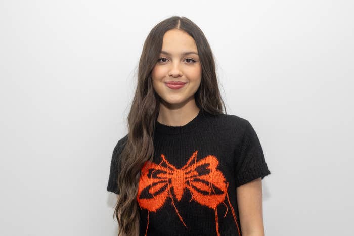 A close-up of Olivia Rodrigo, who is wearing a T-shirt with a butterfly printed on the front