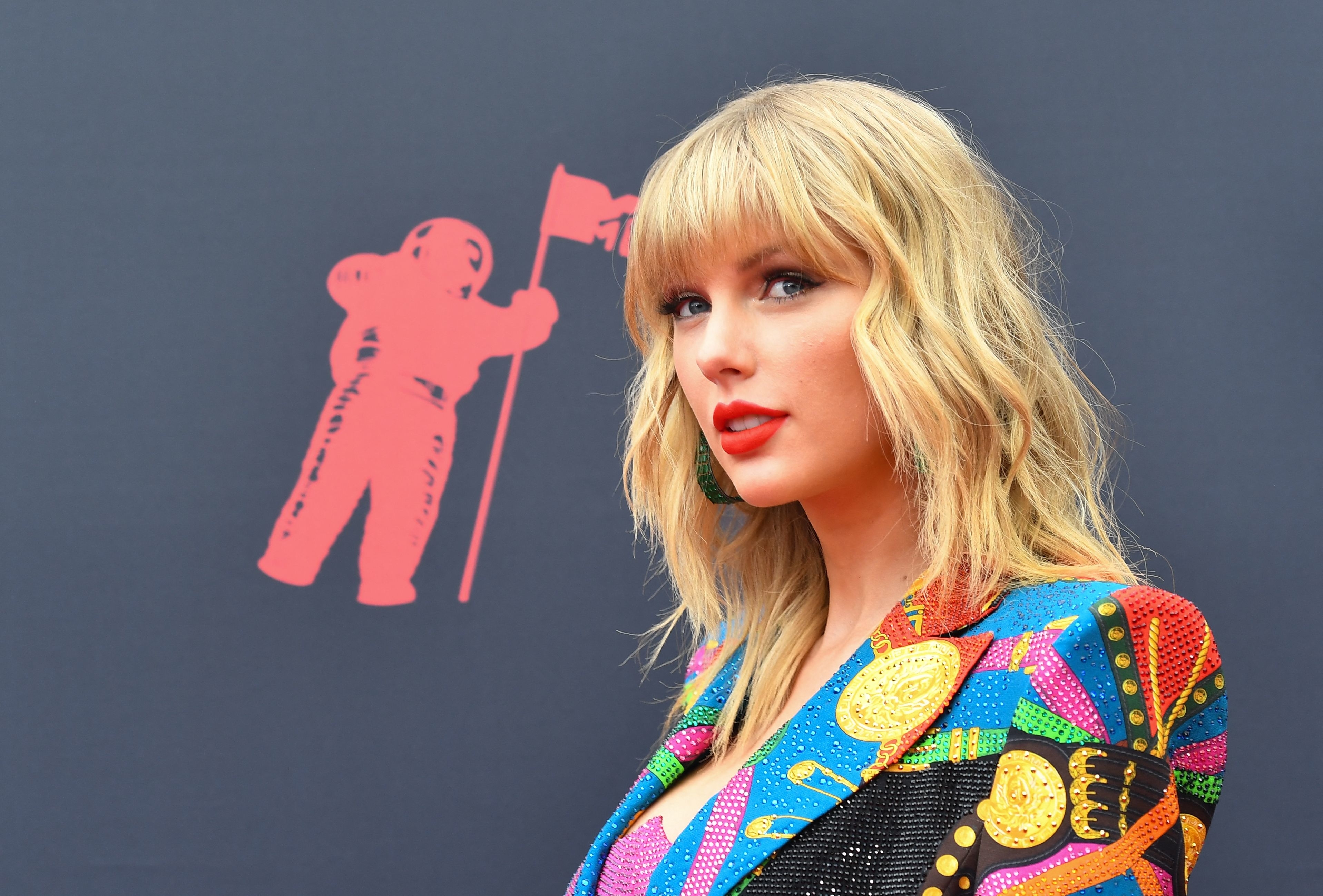 A close-up of Taylor Swift with the MTV VMA astronaut logo behind her