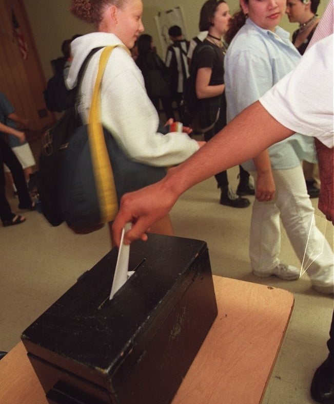 A person putting their vote in a box