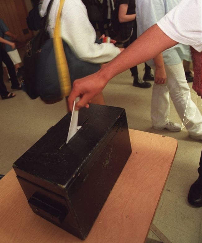 A person putting their vote in a box