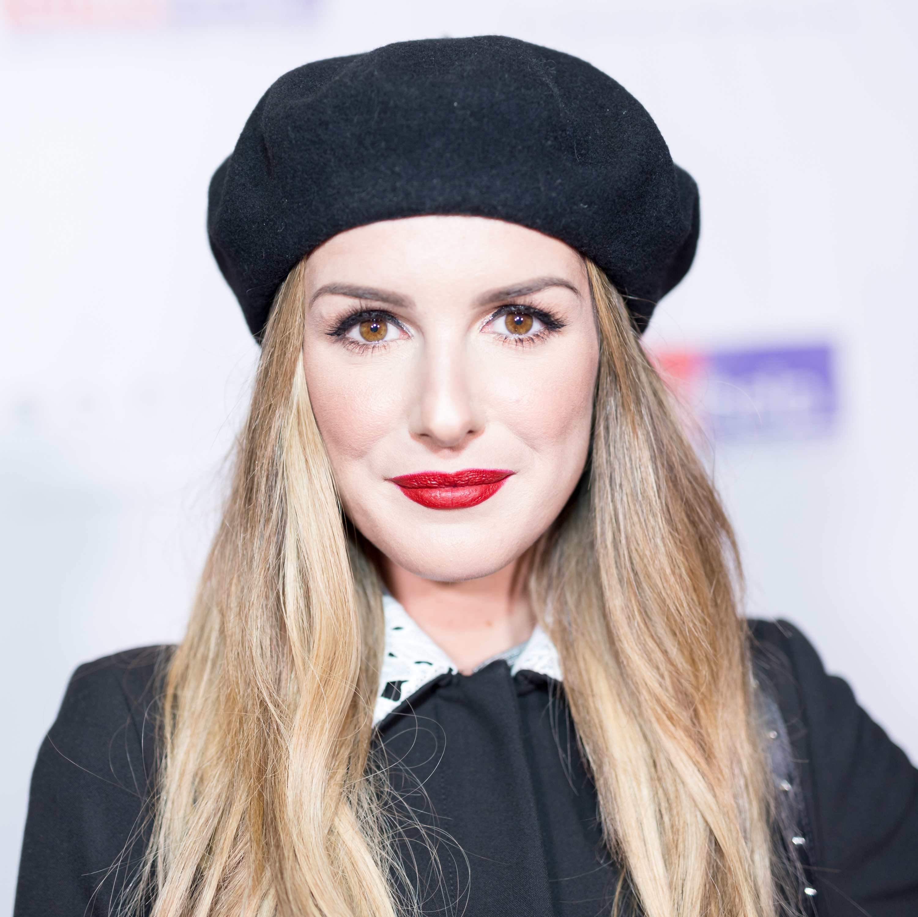 A closeup of Shenae at an event with long hair and wearing a beret