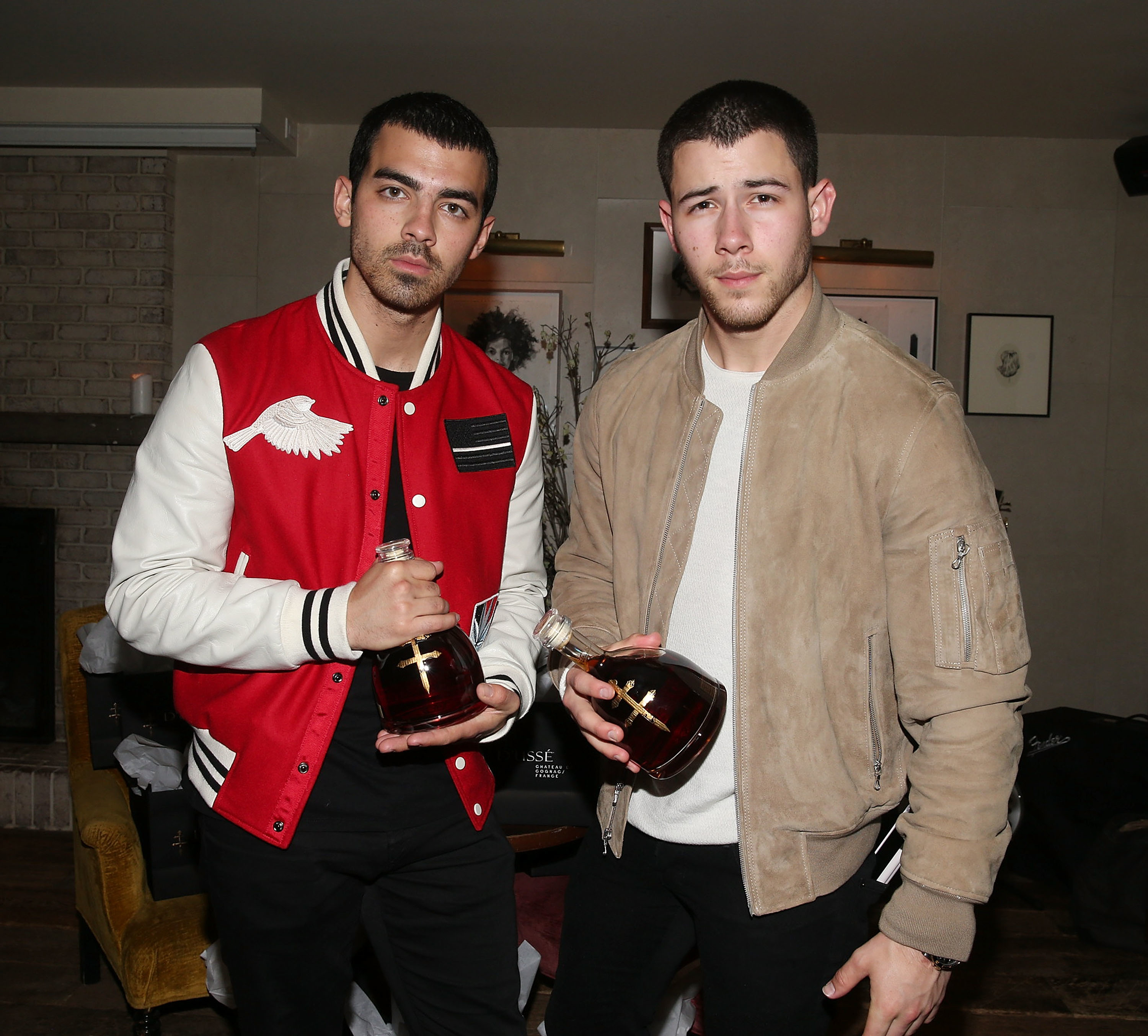 nick and joe at an event holding bottles of liquor