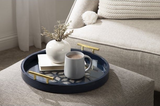 A serving tray holds coffee and a plant