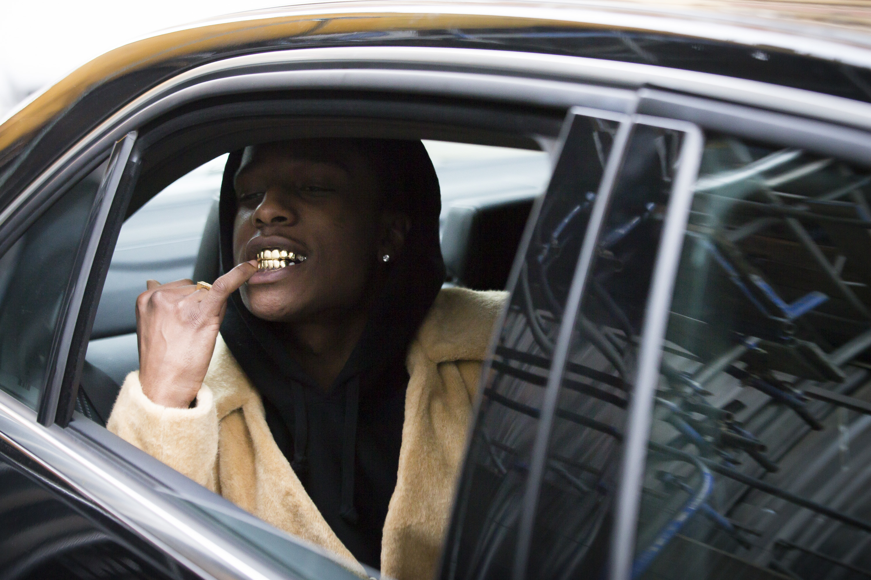 rocky in a car showing off his grill
