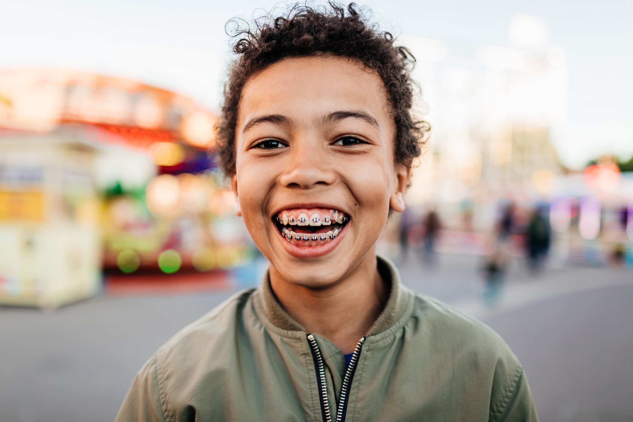 Closeup of a little boy smiling and showing his braces