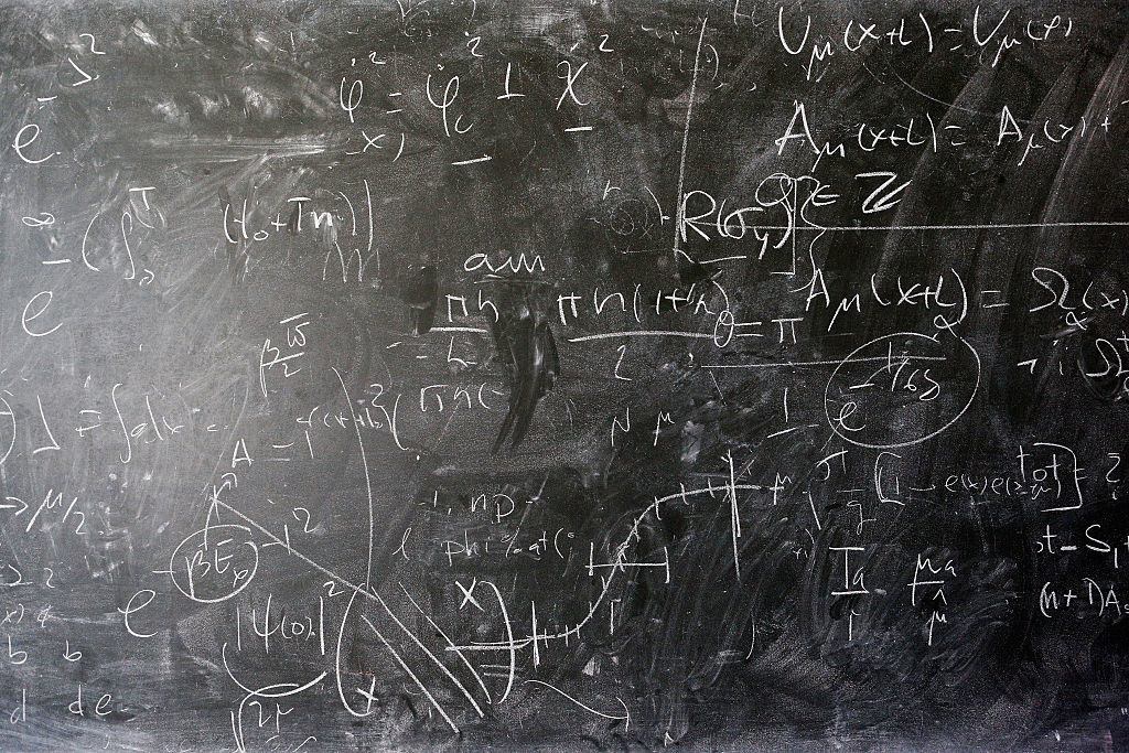 A chalkboard with mathematical equations on it