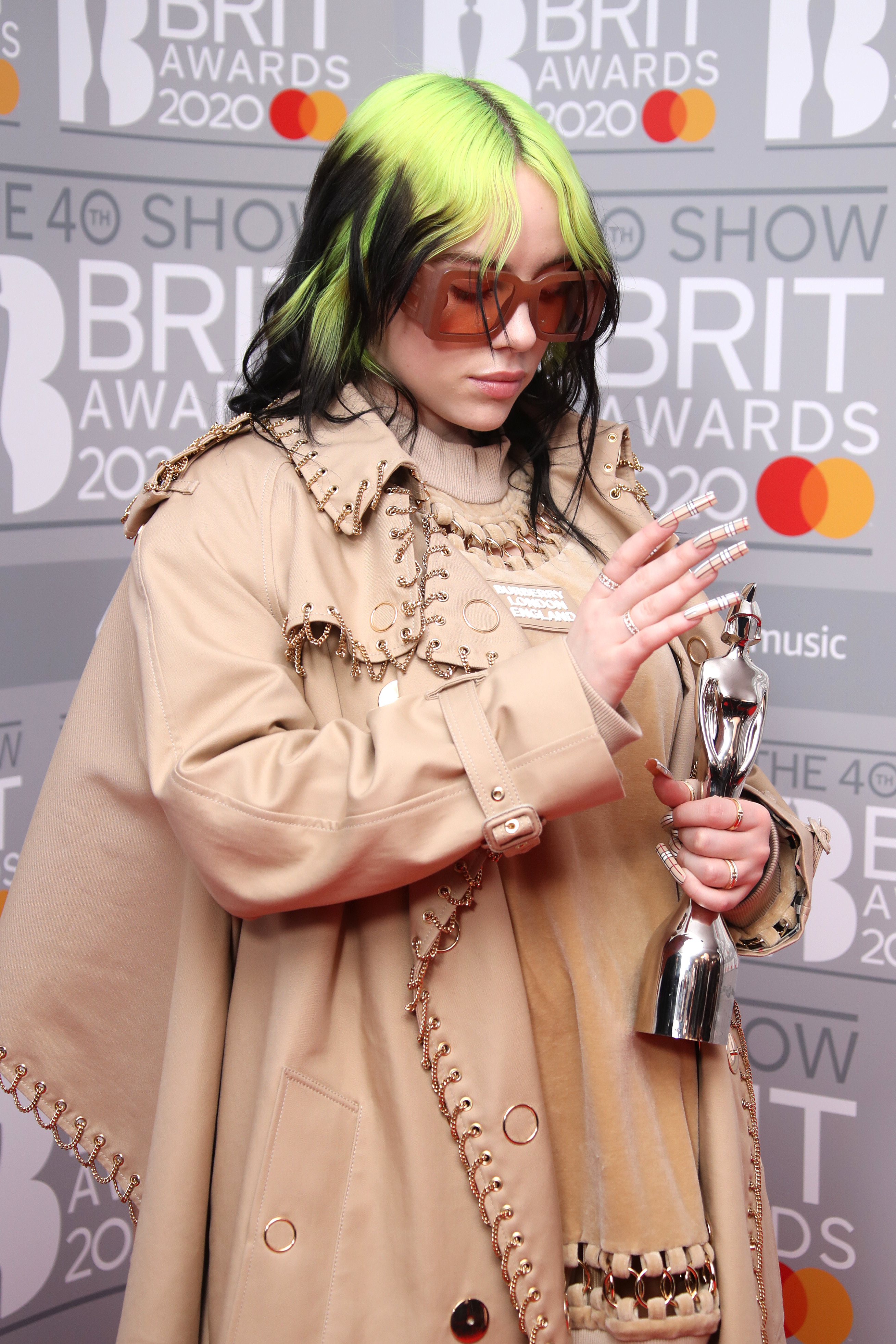 Billie Eilish holding her Brit Award