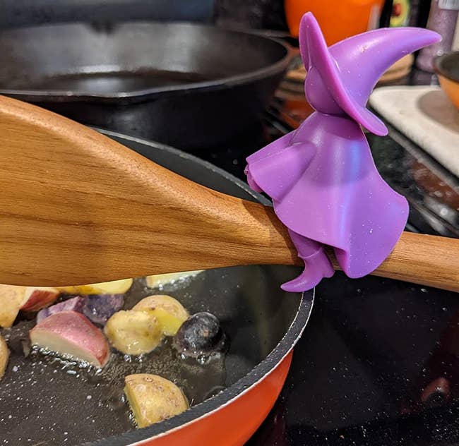 reviewer photo of the purple witch-shaped spoon holder on a wooden spoon