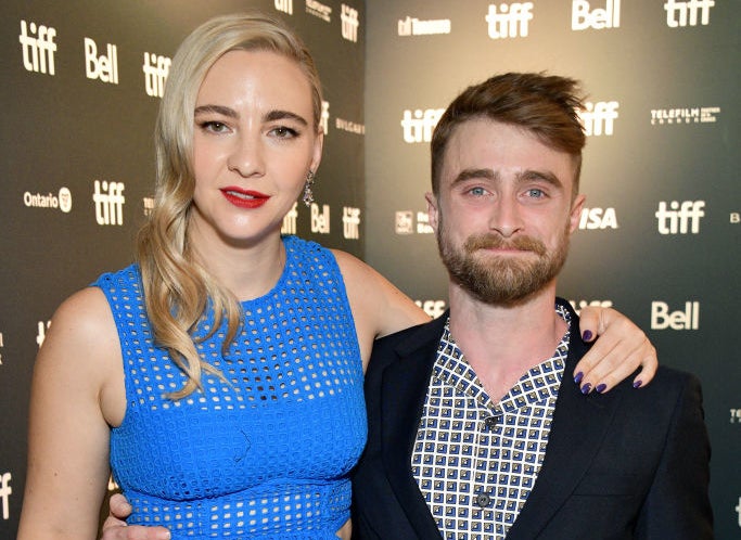 Erin Darke and Daniel with their arms around each other as they smile for cameras on the red carpet