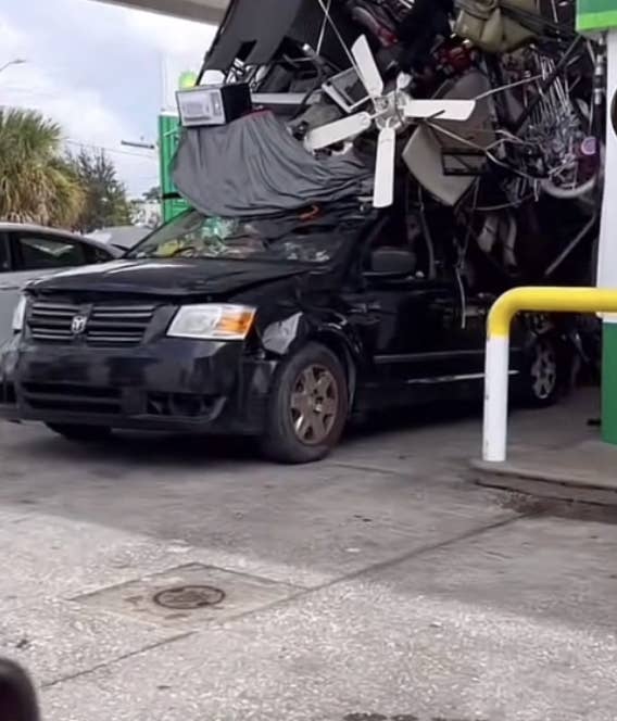 The car with a massive pile of items including a ceiling fan at the gas station