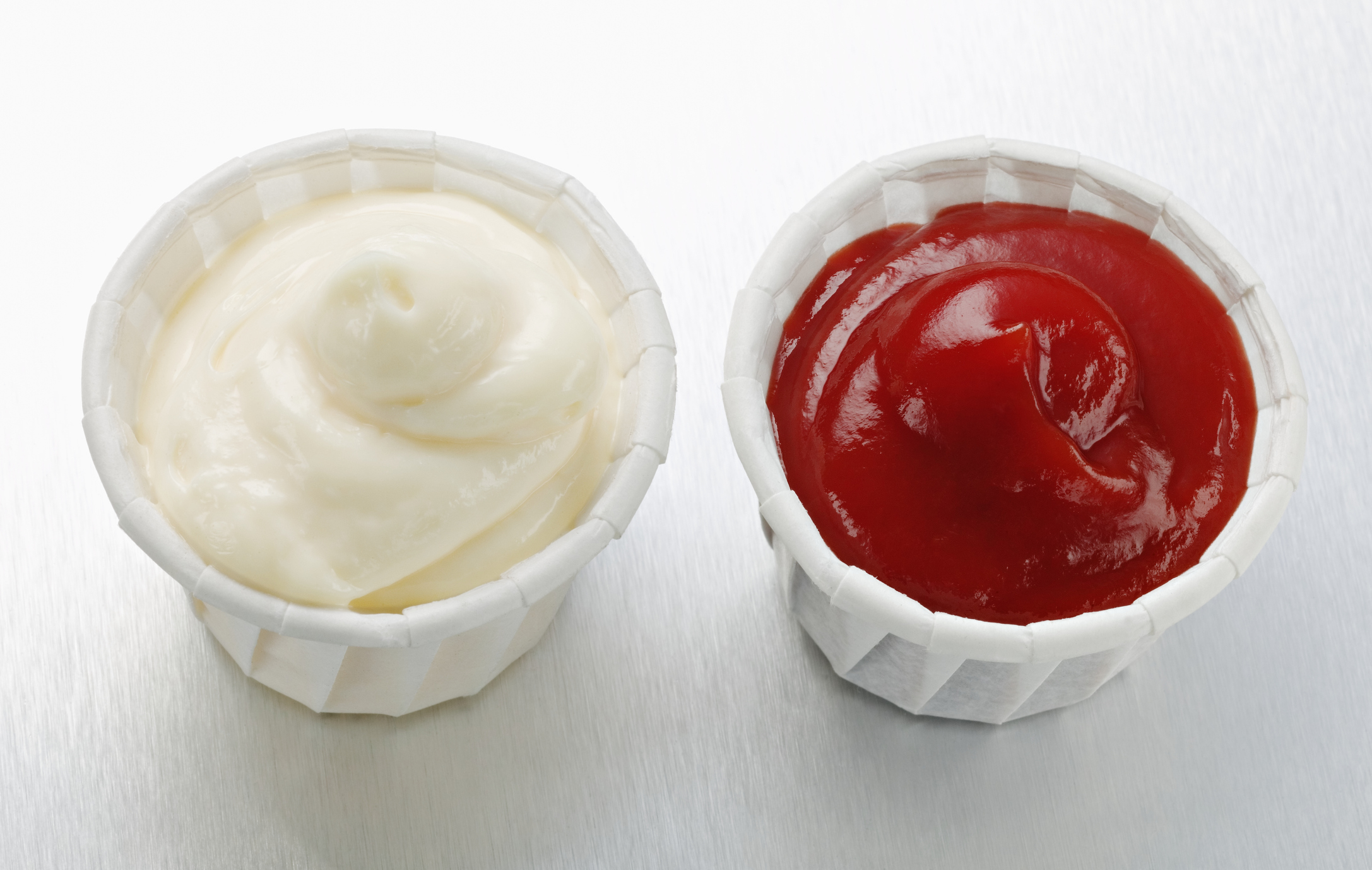 side by side paper serving cups of mayo and ketchup
