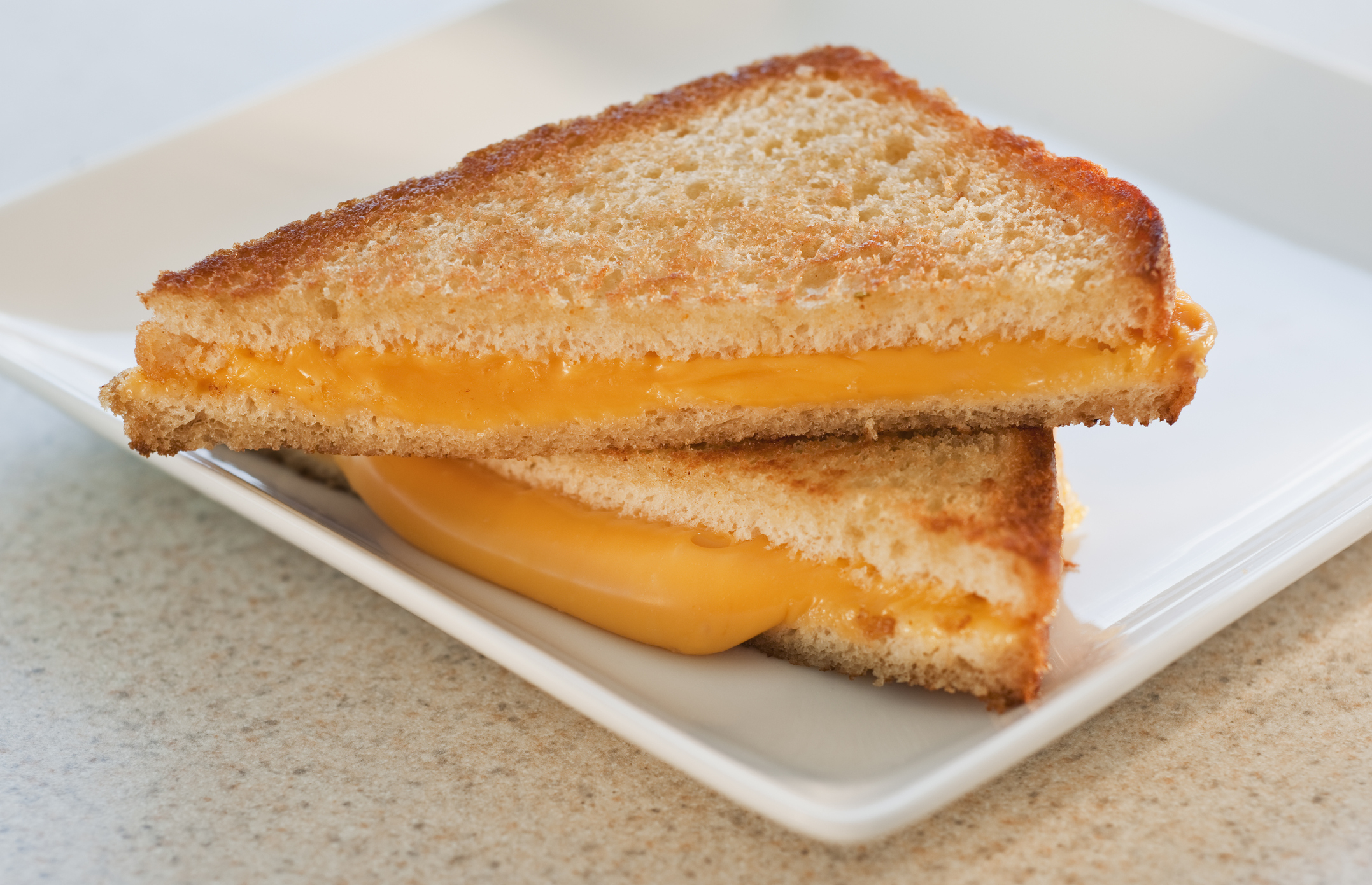 a simple grilled cheese made with white bread and american cheese on a plate