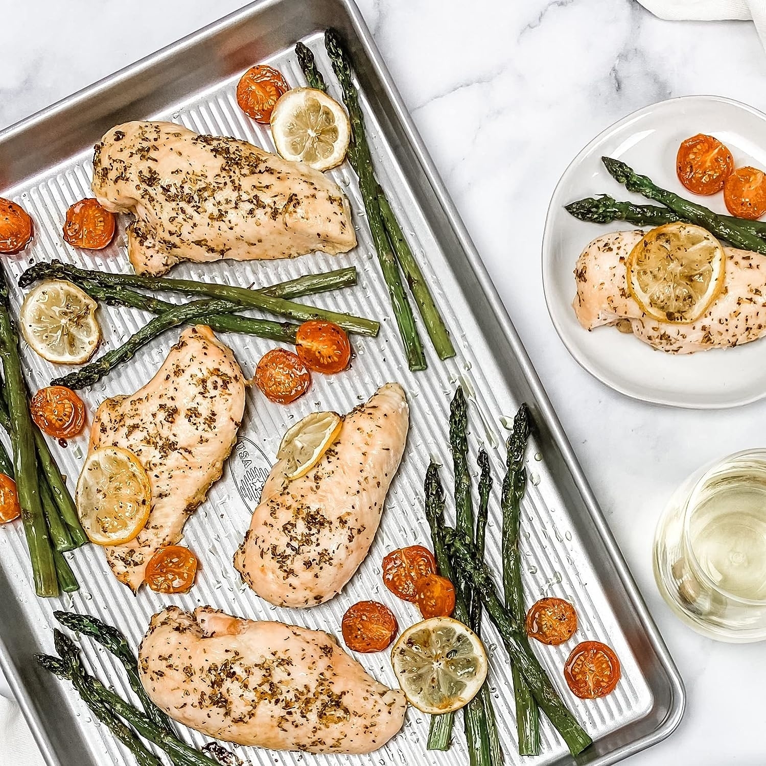 the sheet pan with chicken and vegetables on it