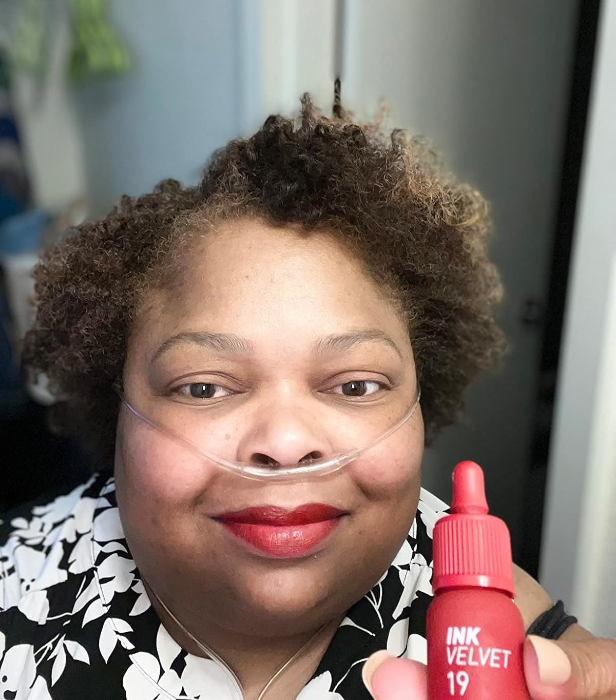 reviewer wearing and holding red lippie
