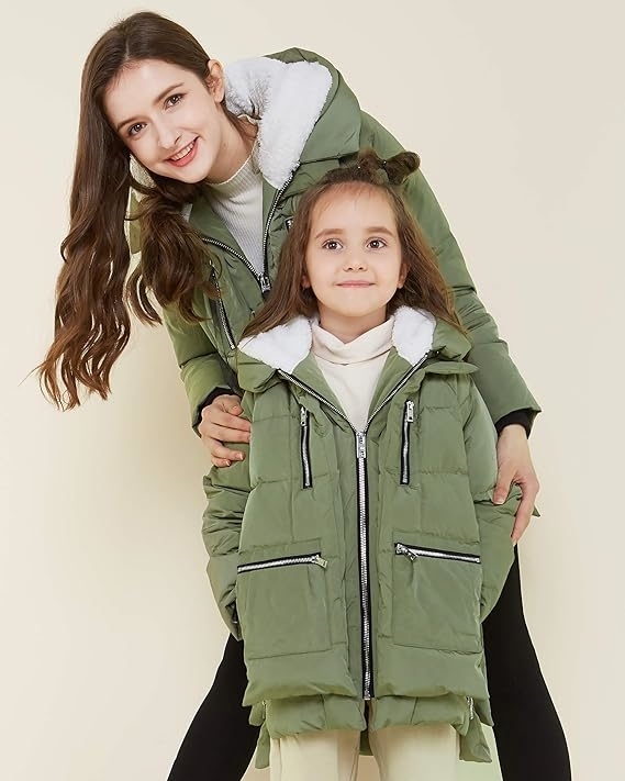 an adult model and a child in matching green winter coats
