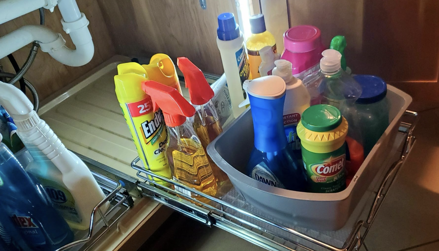 reviewer photo of various cleaning products on the pull out cabinet organizers