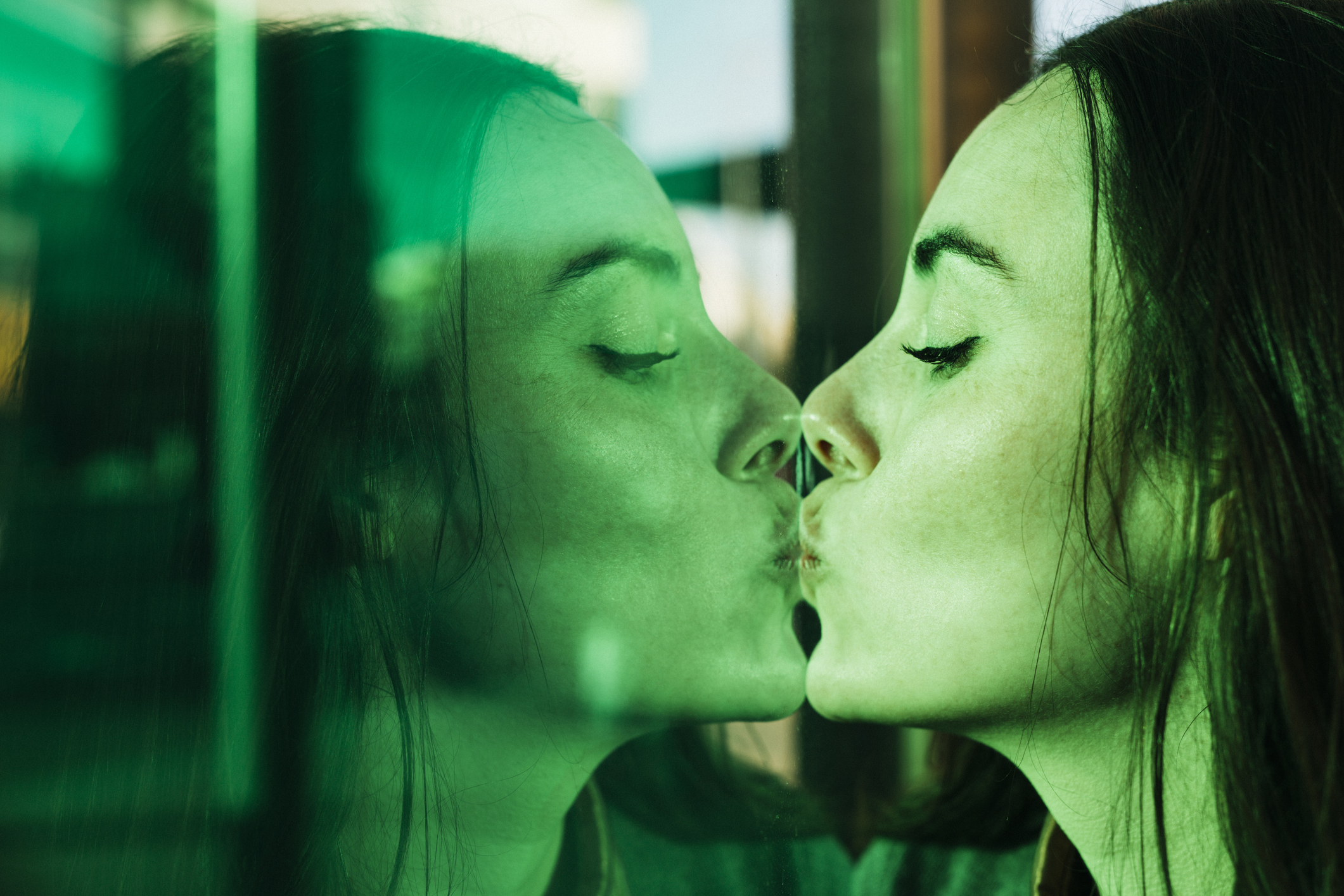 A woman kissing her reflection