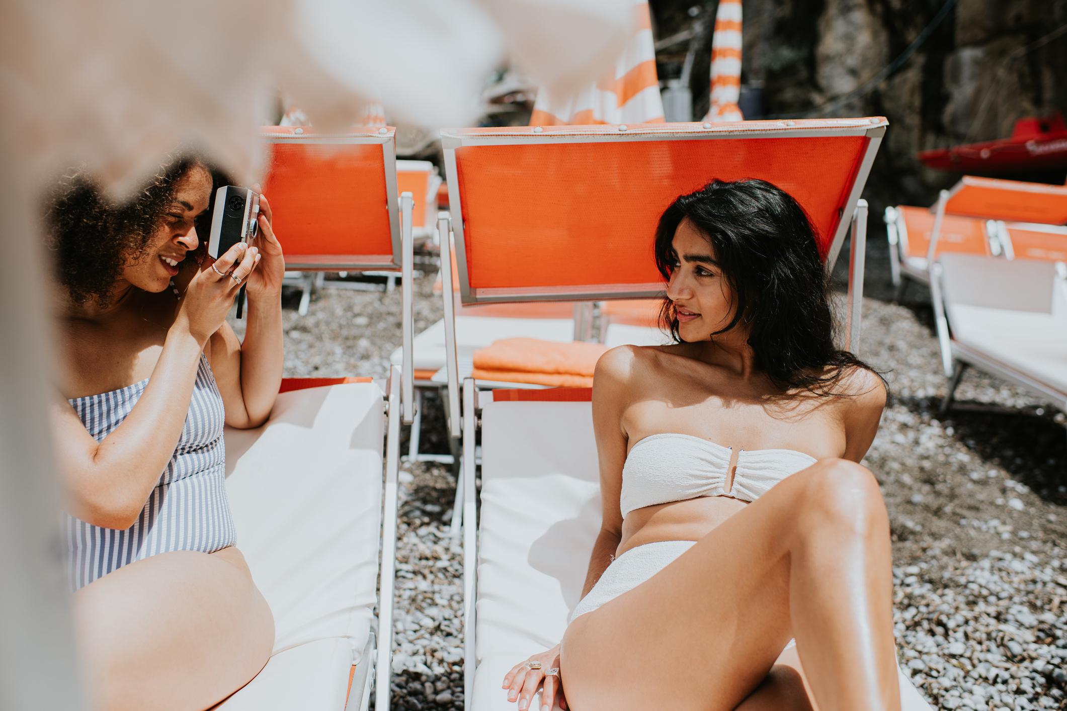 Girls on sunbathing chairs taking bikini photos