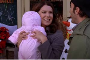 Lorelai gilmore holds a baby and smiles