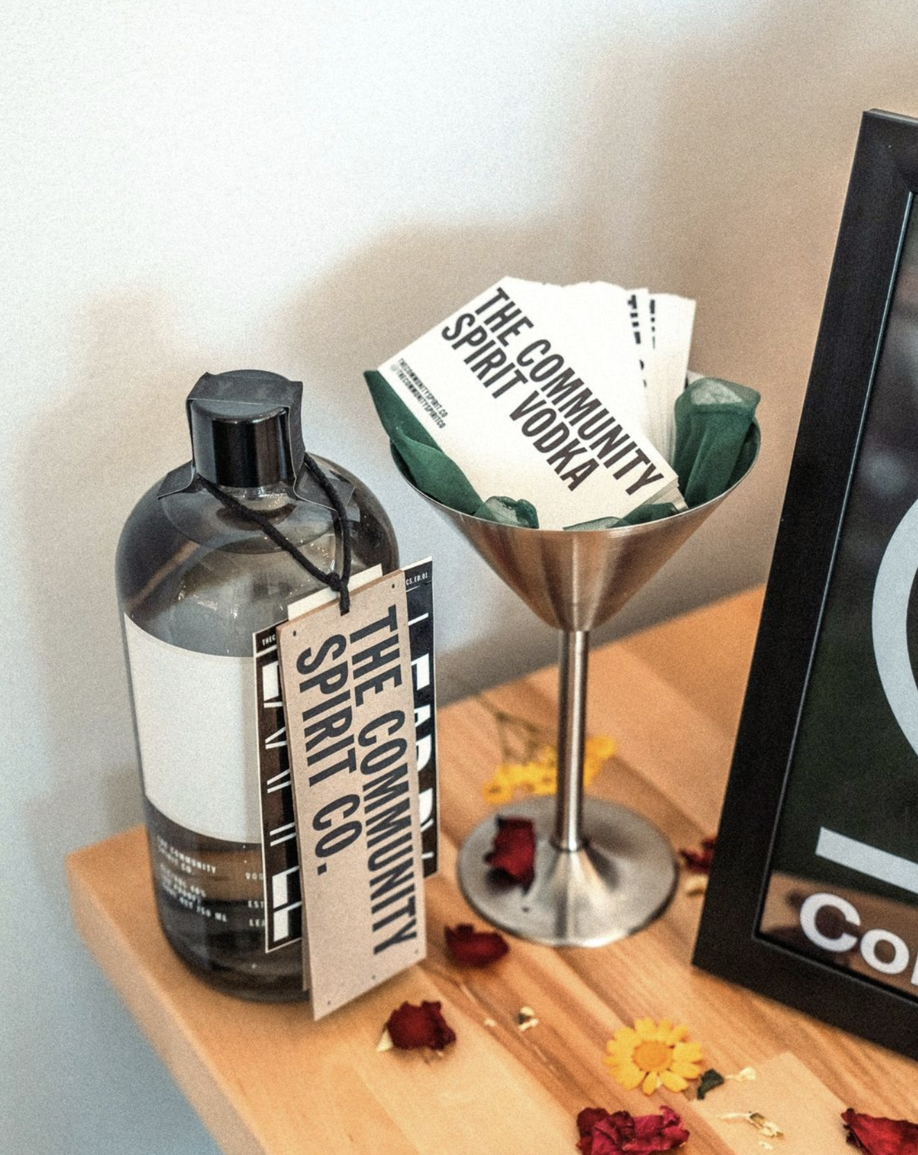 Bottle of Community Spirit Vodka next to martini glass of business cards.
