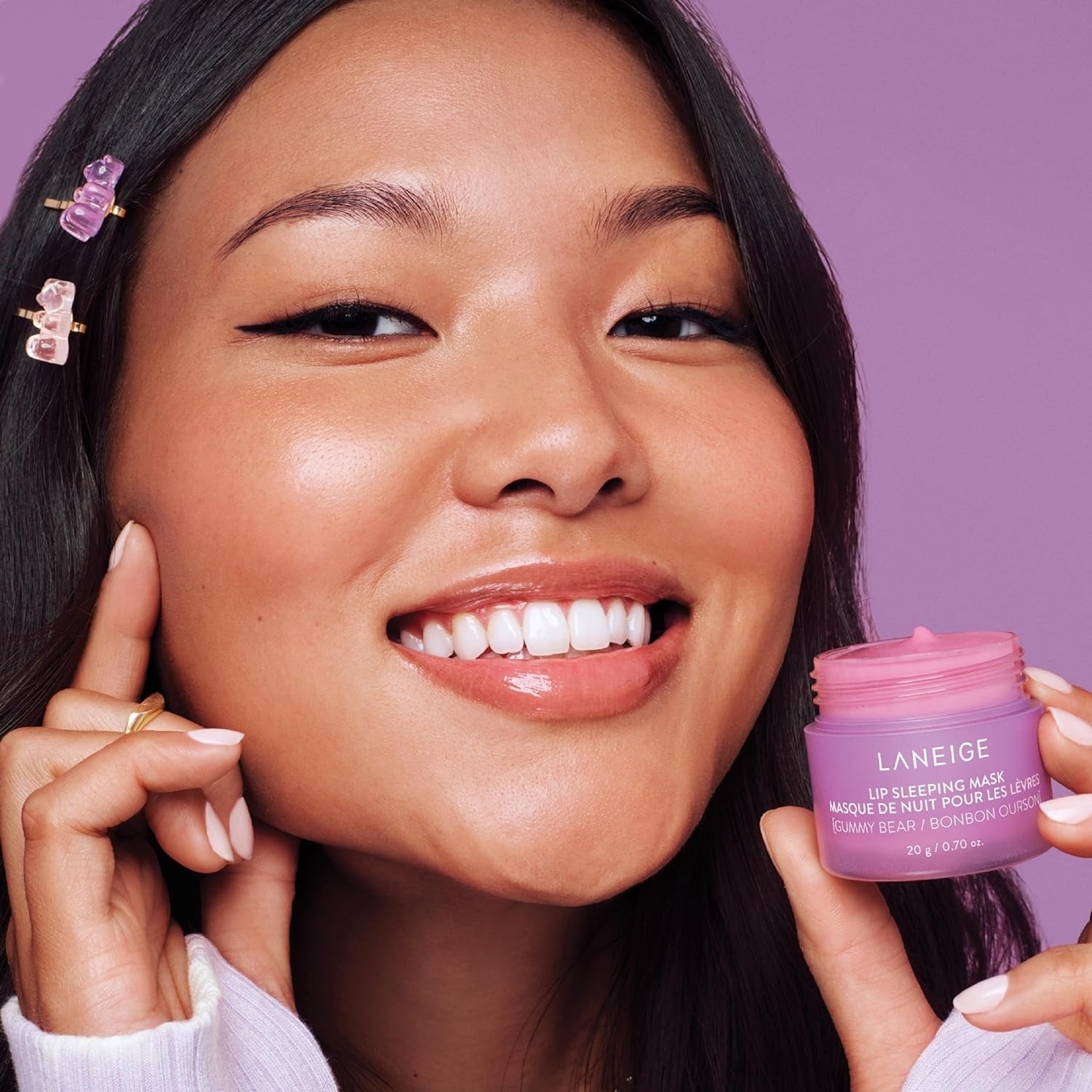 model holding purple container of the Laneige lip mask