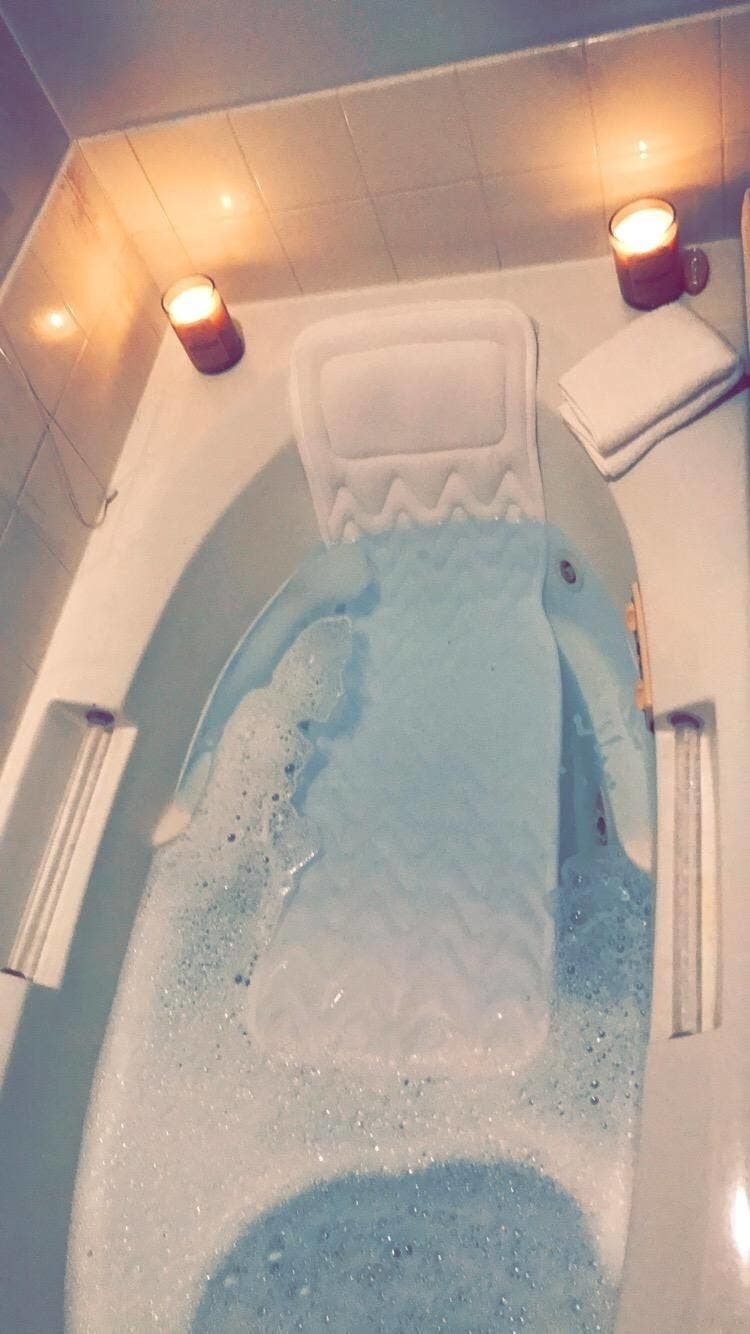 a long bath pillow in a soapy tub