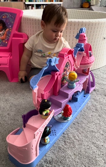 a child playing with a disney princess castle