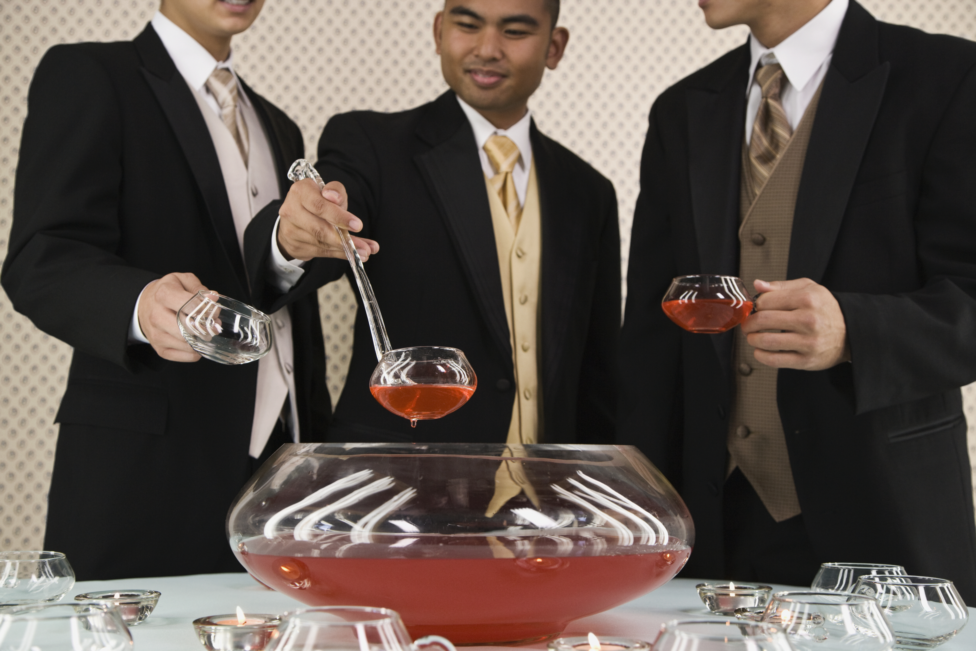 Men in suits around a punch bowl
